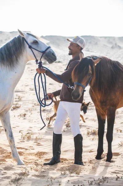 Salah preparing horse tack at Ranch des Dunes