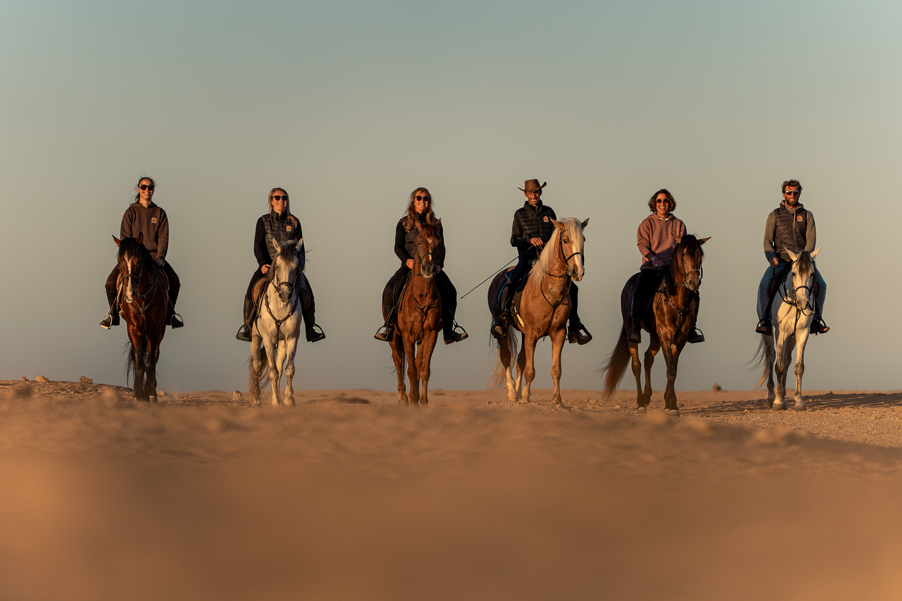 The Ranch des Dunes team on horseback in the dunes of Dakhla at sunset