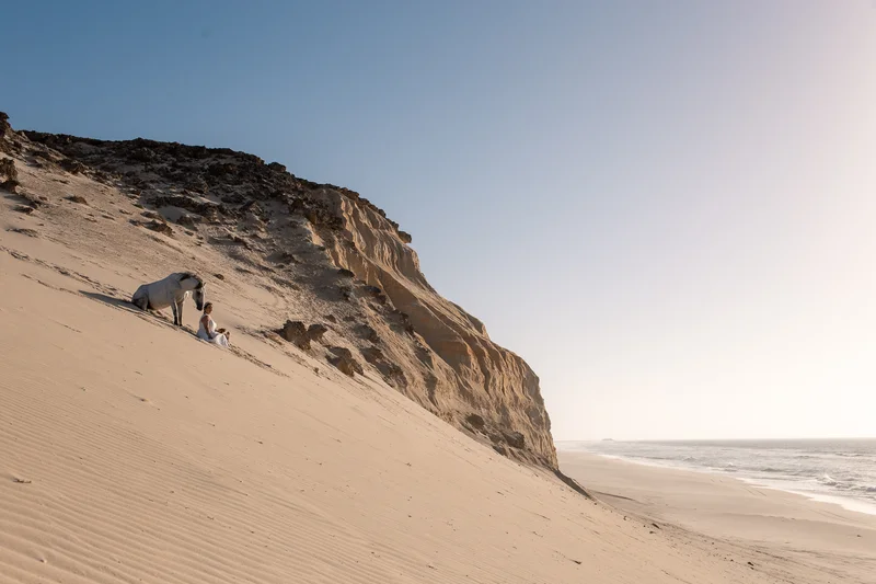 Model with horse in front of ocean cliffs in Dakhla